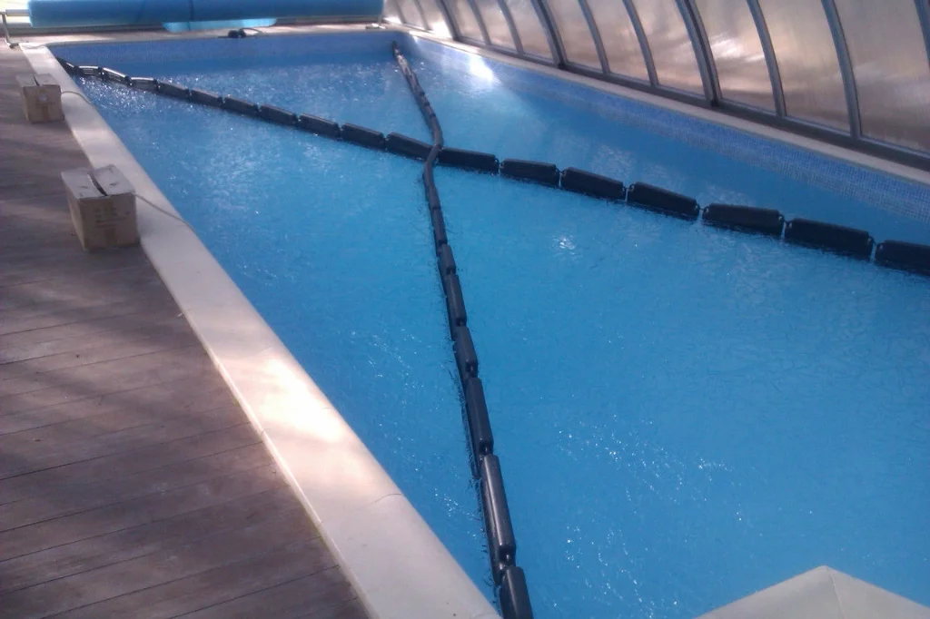 Dispunerea în diagonală a balizelor anti-îngheț pe o piscină dreptunghiulară acoperită cu prelată de iarnă